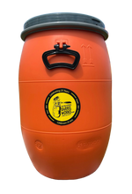 Load image into Gallery viewer, Orange rain barrel with a logo on a stone surface, with kayaks in the background.
