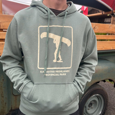 Person wearing a green hoodie with a Portage Icon design in front of a vintage truck 
